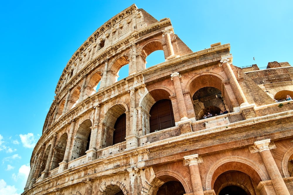 Les ressources - Photo d'une partie du Colisée de Rome avec un ciel bleu et quelques nuages en arrière-plan