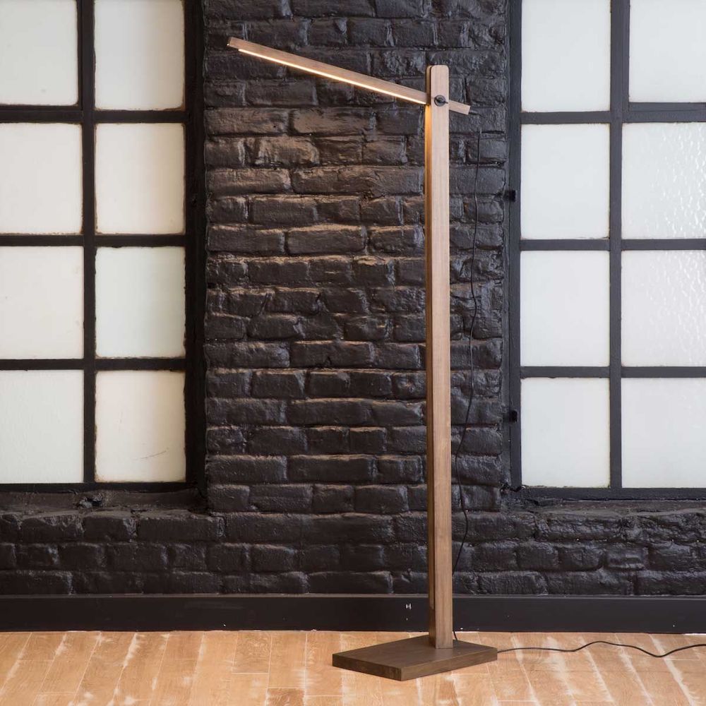 astuces déco présentant une lampe sur pied en bois devant un mur de briques foncées