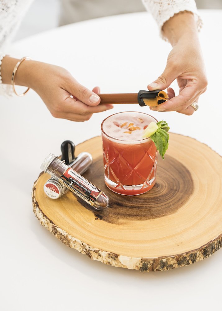 Mains tenant avec des assaisonnements au dessus d'un verre (OCNI Factory)