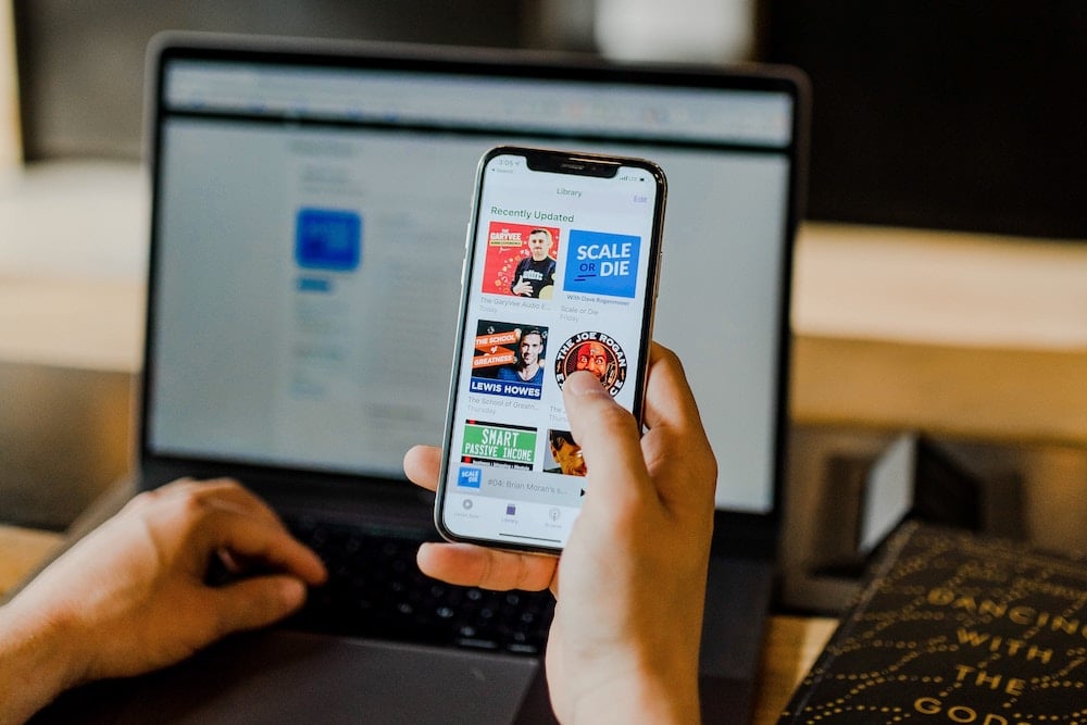 Téléphone portable tenu par une main qui navigue sur une page (Vendredi fou)