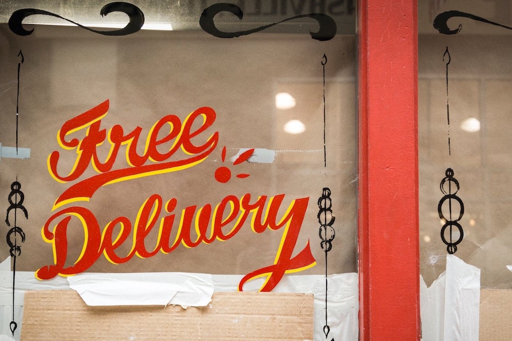 Vitrine de magasin où il est écrit "Free Delivery" (Vendredi fou)