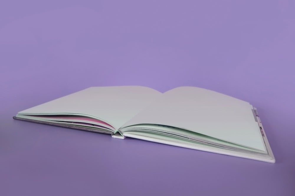 Livre de pages blanches ouvert sur un fond mauve (personne toxique)