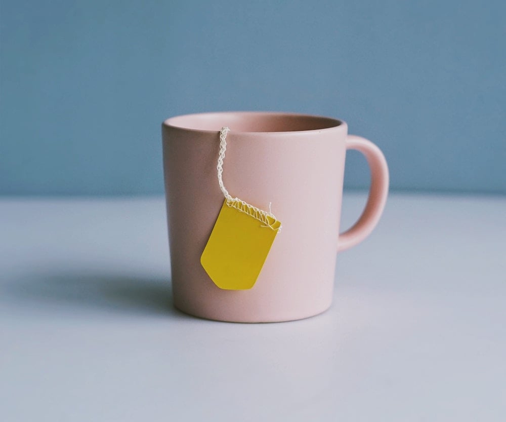Année - Tasse rose pâle sur une surface blanche et un fond bleu