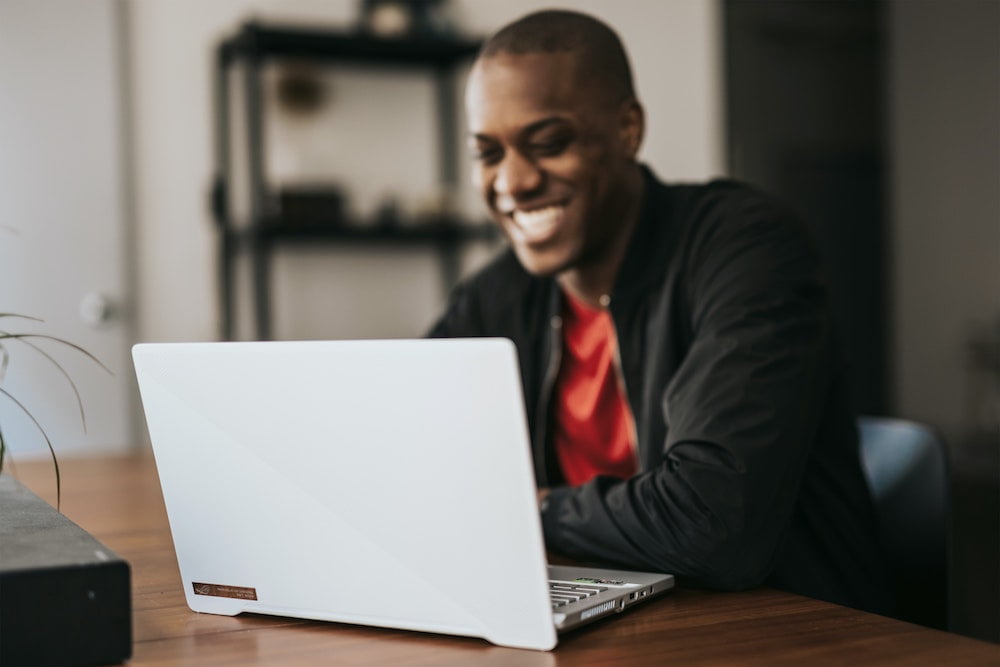 Intention de vente | Homme qui sourit devant son ordinateur portable